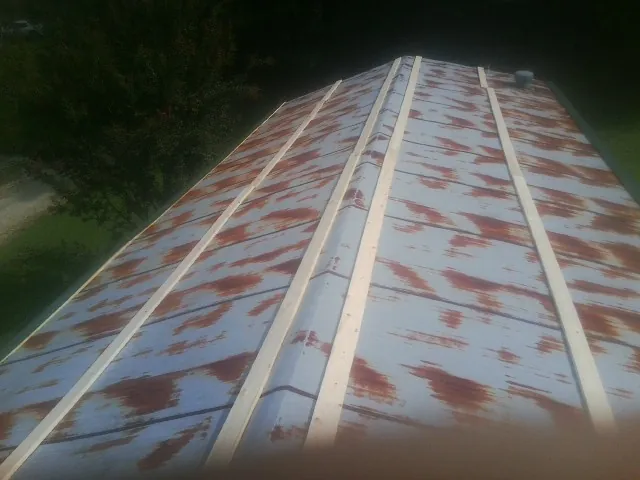Rusted metal roof panels with new wood purlins before replacement — Storm Damage Roof Repair in Carbondale by Roofing Brothers